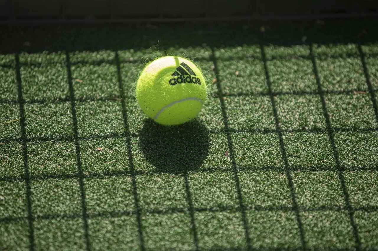 Tennisbold på bane med skygge fra net